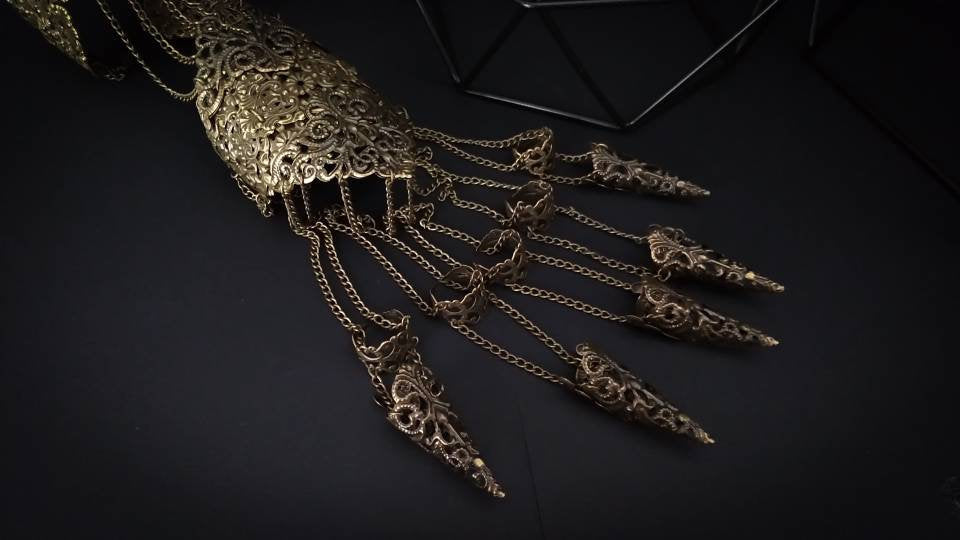 This intricate Full Hand Armor with Long Claws from Myril Jewels embodies the dark, avant-garde spirit of neo-gothic artistry. Designed for bold statement-making, it's a fusion of Halloween and punk jewelry aesthetics, ideal for witchcore enthusiasts, festival-goers, and those embracing a minimal goth lifestyle