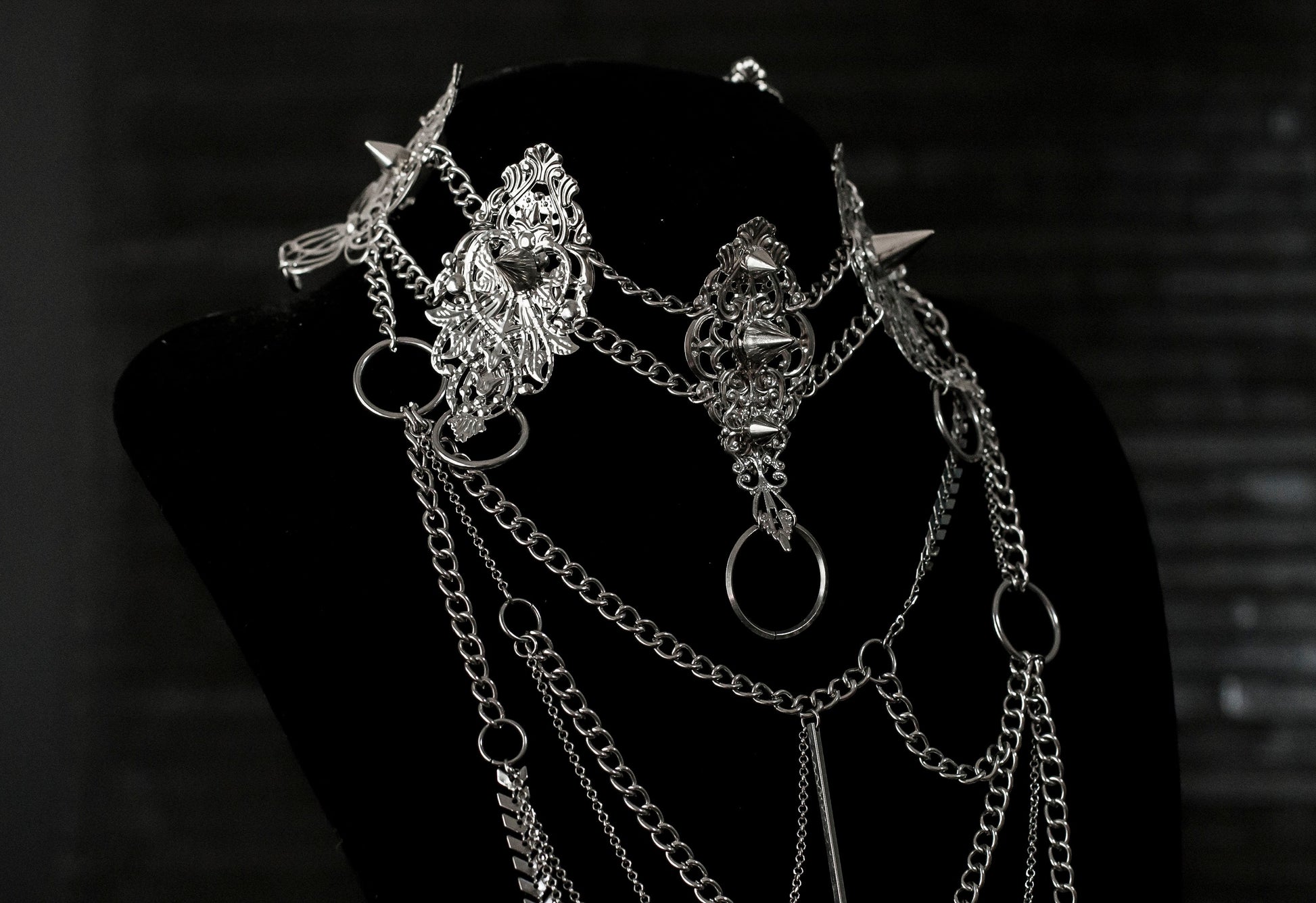 Myril Jewels presents an exquisite punk studded metal choker paired with a multi-layer long chain necklace, embodying the dark avant-garde spirit. This Italian handcrafted ensemble is a testament to the fusion of Neo Gothic flair and Gothic-chic, perfect for Halloween, everyday wear, or any whimsigoth and witchcore inspired look. The layered chains add depth to the minimal goth aesthetic, making it a versatile statement piece for alternative style connoisseurs