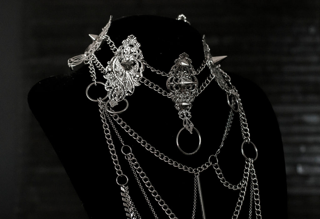 Myril Jewels presents an exquisite punk studded metal choker paired with a multi-layer long chain necklace, embodying the dark avant-garde spirit. This Italian handcrafted ensemble is a testament to the fusion of Neo Gothic flair and Gothic-chic, perfect for Halloween, everyday wear, or any whimsigoth and witchcore inspired look. The layered chains add depth to the minimal goth aesthetic, making it a versatile statement piece for alternative style connoisseurs