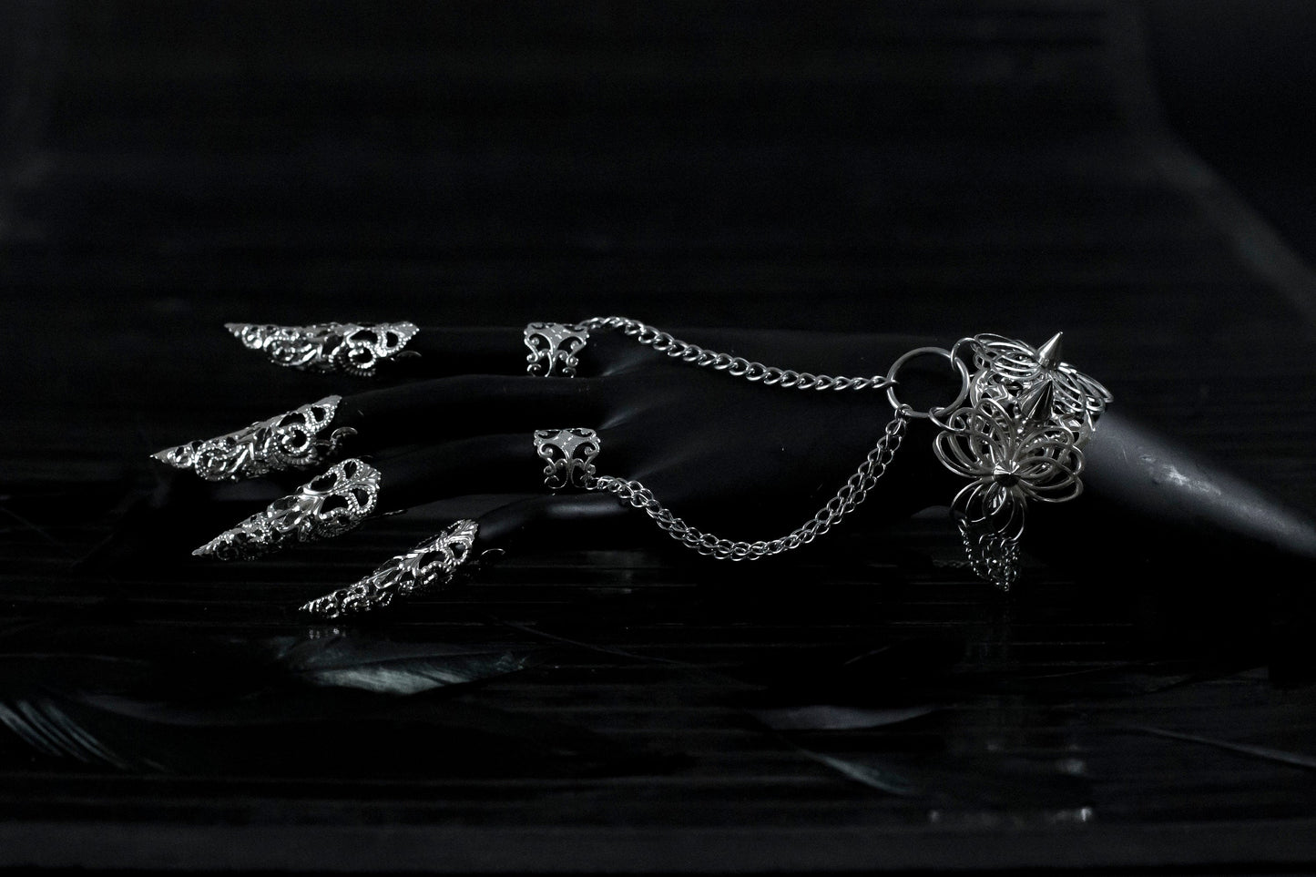 This striking Myril Jewels punk jewelry set, featuring a hand chain bracelet with ring, and nail claw rings, exemplifies the cutting-edge style of dark avant-garde fashion. Crafted with precision, the set's silver studs and intricate filigree cater to enthusiasts of Neo Gothic and Gothic-chic trends, making it an ideal choice for Halloween, everyday wear, and special occasions like rave parties and festivals. Each piece is designed to make a bold statement