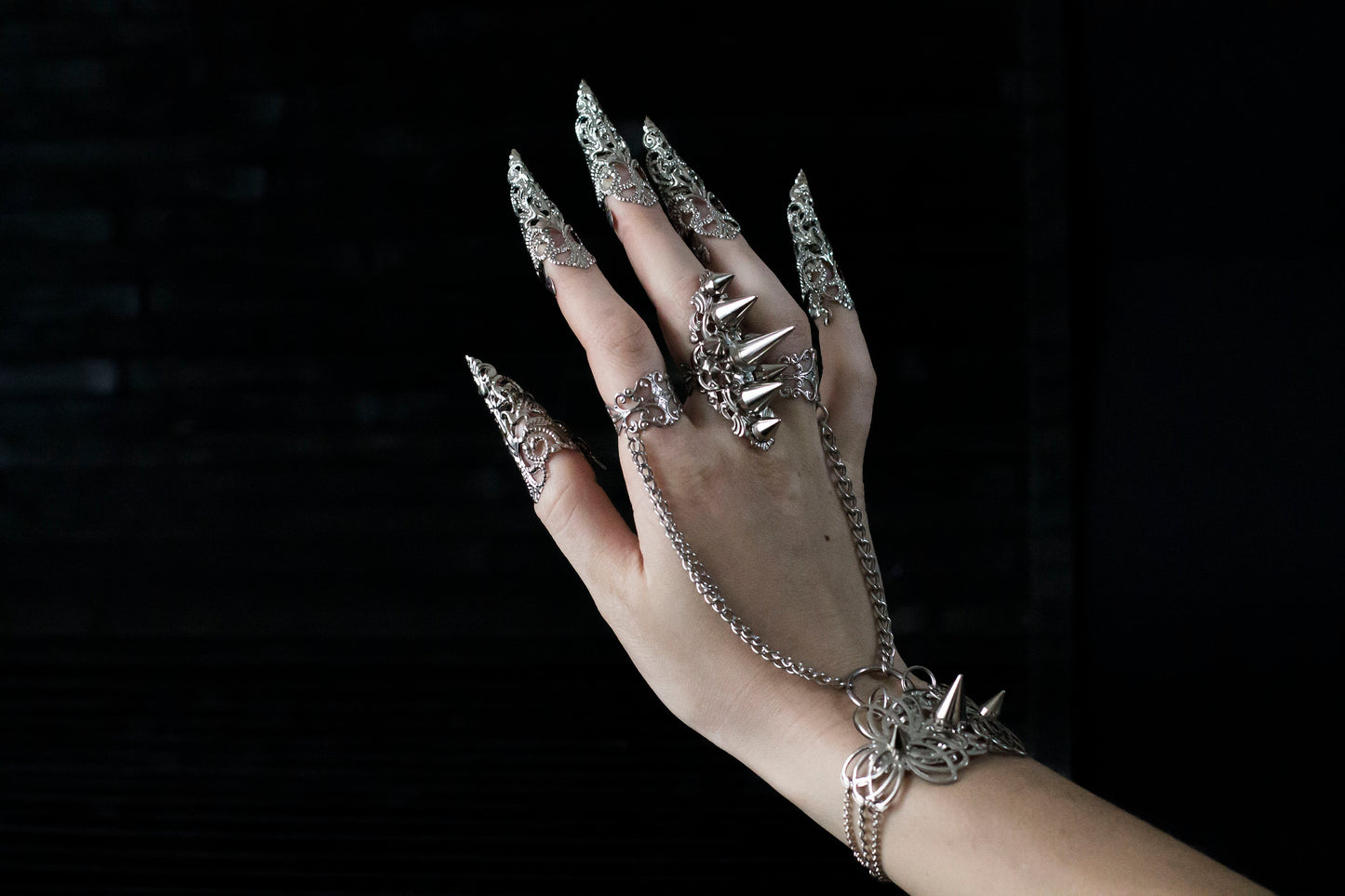 Capture the essence of punk rebellion with Myril Jewels' edgy studded ring with matching hand chain bracelet ring and nail claw rings . These bold statement pieces, with its sharp studs and metallic finish, are a must-have for lovers of dark-avantgarde and gothic accessories. Ideal for Halloween, it also complements everyday minimal goth looks, Witchcore styles, and Gothic-chic ensembles, offering a versatile addition to any Neo Gothic jewel collection