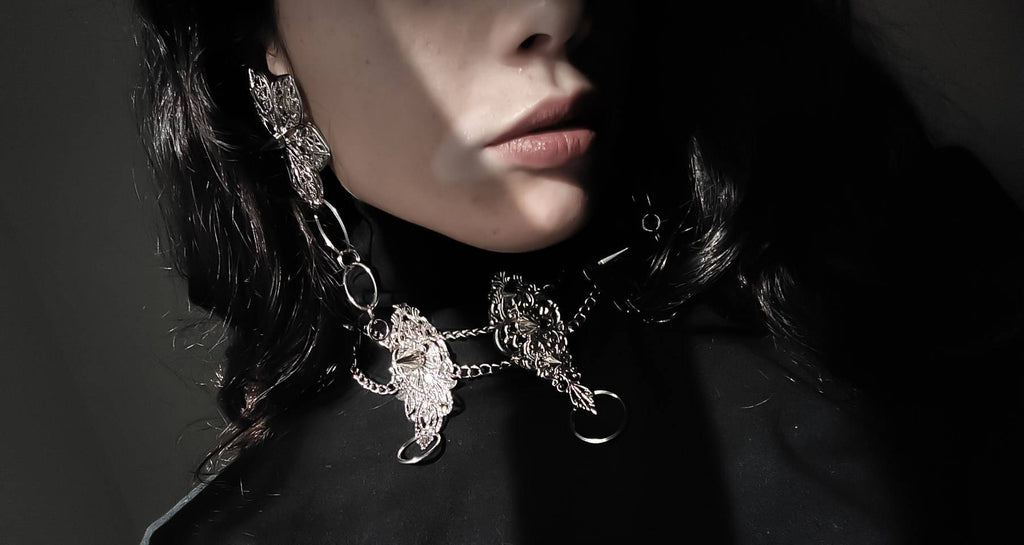 A close-up image captures the essence of Myril Jewels' craftsmanship with a punk studded metal choker adorned by an alternative model. The intricate design and studded detailing reflect a Neo Gothic influence, making it a coveted piece for those who appreciate Halloween jewelry, punk style, and Gothic-chic trends. The choker's bold presence is perfect for Whimsigoth and Witchcore enthusiasts or as a distinct touch to minimal goth daily wear