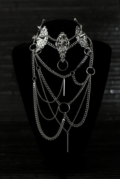 Myril Jewels presents an exquisite punk studded metal choker paired with a multi-layer long chain necklace, embodying the dark avant-garde spirit. This Italian handcrafted ensemble is a testament to the fusion of Neo Gothic flair and Gothic-chic, perfect for Halloween, everyday wear, or any whimsigoth and witchcore inspired look. The layered chains add depth to the minimal goth aesthetic, making it a versatile statement piece for alternative style connoisseurs