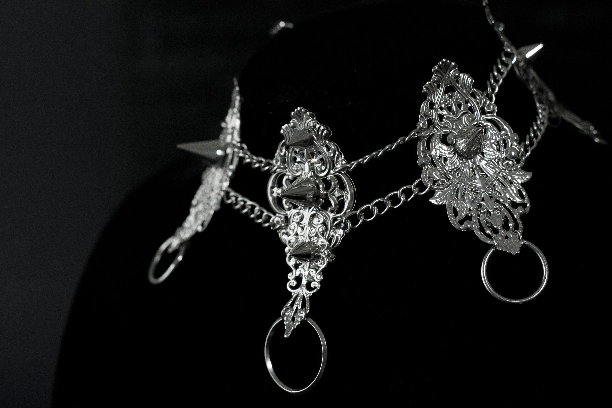 An exquisite Myril Jewels punk studded metal choker displayed on a dark backdrop, radiating gothic allure and alternative sophistication. This handcrafted Italian piece, with its intricate filigree and bold metal studs, is a true representation of Neo Gothic finesse. Ideal for those who gravitate towards Gothic Lolita, Gothic-chic, and whimsigoth aesthetics, it's a striking choice for Halloween jewelry collectors and embodies the witchcore vibe for everyday minimal goth fashion.