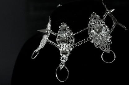 An exquisite Myril Jewels punk studded metal choker displayed on a dark backdrop, radiating gothic allure and alternative sophistication. This handcrafted Italian piece, with its intricate filigree and bold metal studs, is a true representation of Neo Gothic finesse. Ideal for those who gravitate towards Gothic Lolita, Gothic-chic, and whimsigoth aesthetics, it's a striking choice for Halloween jewelry collectors and embodies the witchcore vibe for everyday minimal goth fashion.