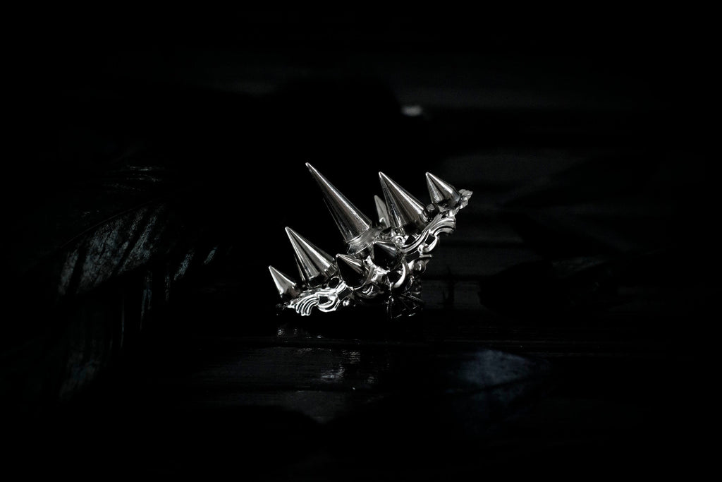 This bold Myril Jewels punk studded ring stands out with its gleaming silver spikes and intricate filigree detailing that pays homage to Neo Gothic craftsmanship. Perfect for anyone seeking a statement piece that channels Gothic-chic or Witchcore vibes, the ring is a quintessential accessory for Halloween, dramatic everyday wear, and a striking complement to any minimal goth or Whimsigoth inspired outfit.