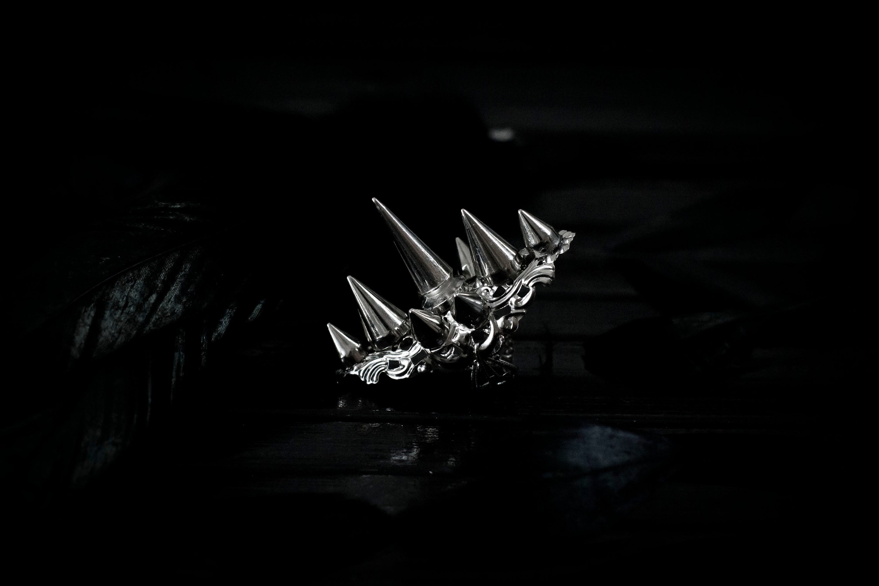 This bold Myril Jewels punk studded ring stands out with its gleaming silver spikes and intricate filigree detailing that pays homage to Neo Gothic craftsmanship. Perfect for anyone seeking a statement piece that channels Gothic-chic or Witchcore vibes, the ring is a quintessential accessory for Halloween, dramatic everyday wear, and a striking complement to any minimal goth or Whimsigoth inspired outfit.