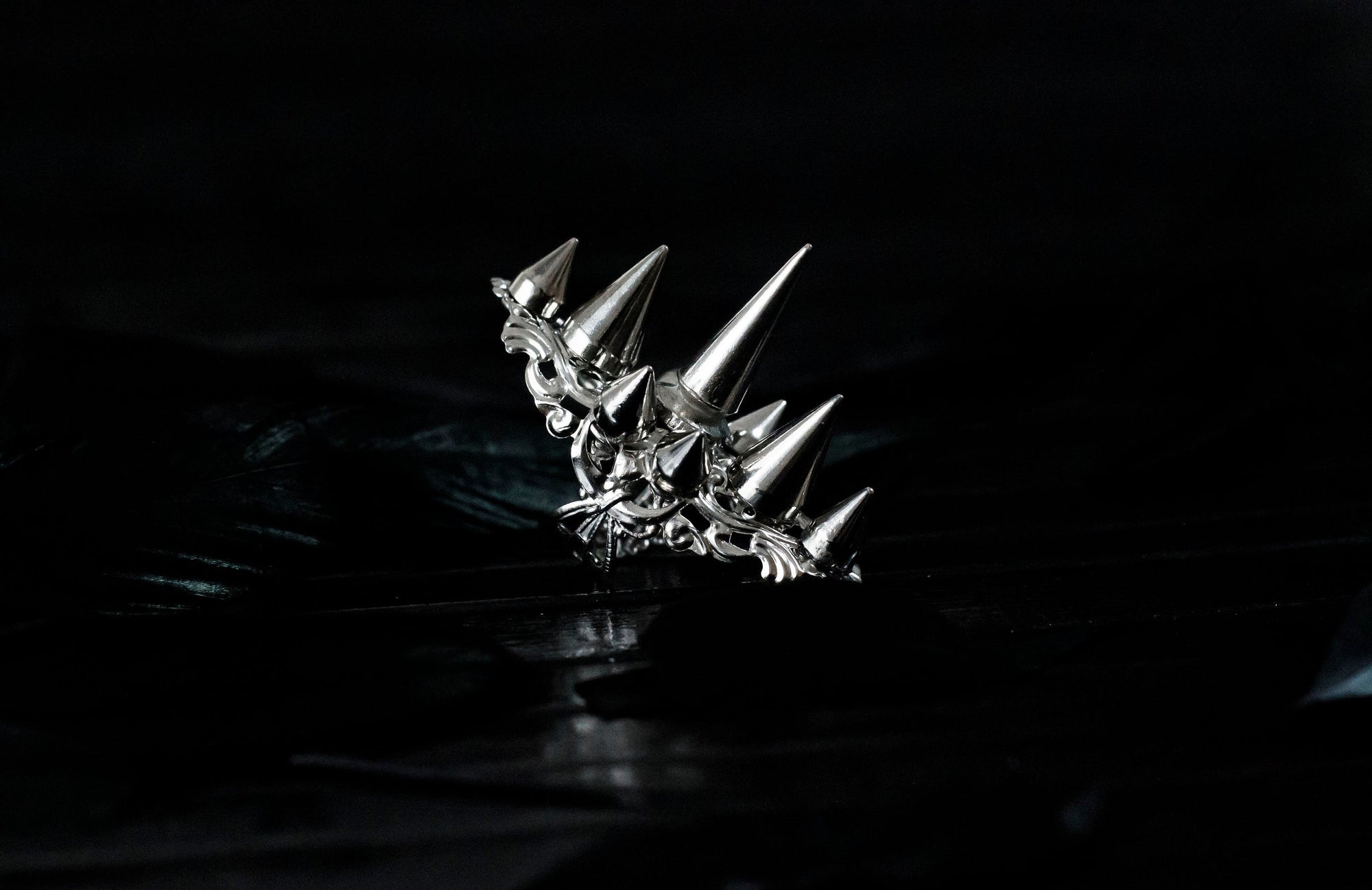 This Myril Jewels silver punk studded ring makes a bold statement with its sharp, gleaming spikes and intricate filigree detailing. Crafted for the dark avant-garde jewelry aficionado, it's a piece that commands attention, perfect for Halloween, embracing the Neo Gothic vibe, or elevating everyday wear with a touch of gothic-chic. Ideal for those who identify with the Whimsigoth or Witchcore aesthetic, or for anyone looking to add an edge to their minimal goth style.