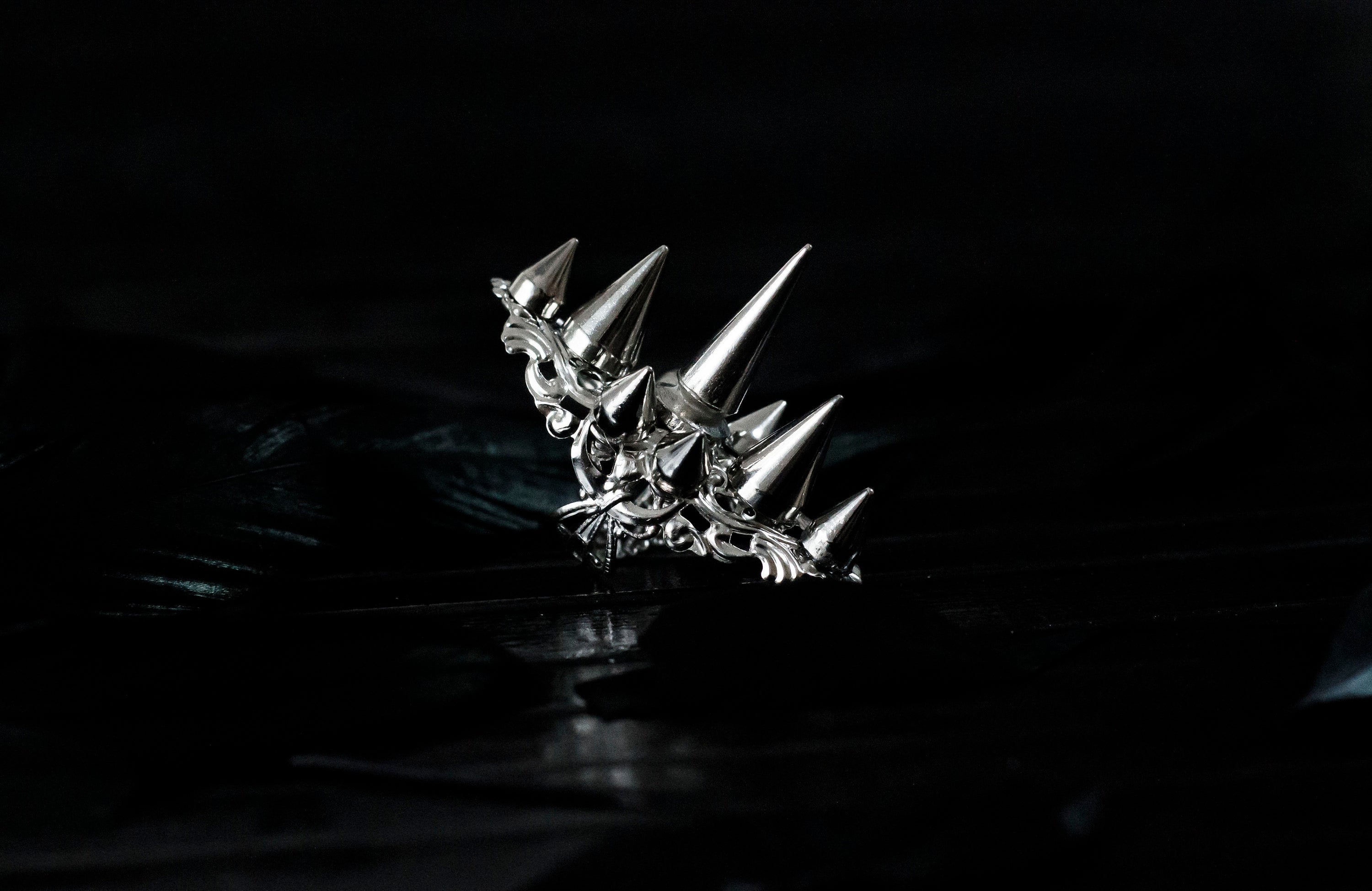 This Myril Jewels silver punk studded ring makes a bold statement with its sharp, gleaming spikes and intricate filigree detailing. Crafted for the dark avant-garde jewelry aficionado, it's a piece that commands attention, perfect for Halloween, embracing the Neo Gothic vibe, or elevating everyday wear with a touch of gothic-chic. Ideal for those who identify with the Whimsigoth or Witchcore aesthetic, or for anyone looking to add an edge to their minimal goth style.