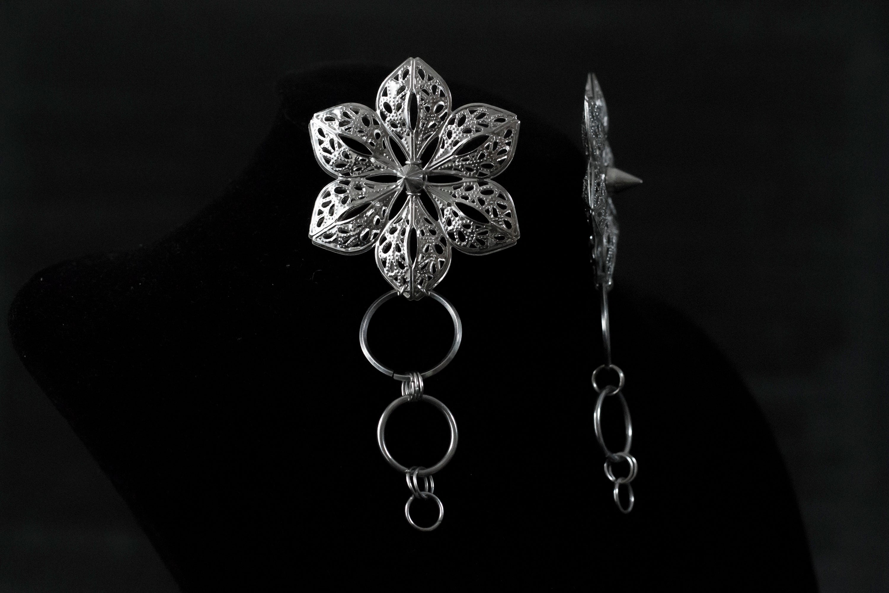 Striking Myril Jewels floral earrings, embodying a bold punk aesthetic with studded detailing, perfect for the dark avant-garde jewelry enthusiast. These handcrafted pieces capture the essence of Neo Gothic charm, making a statement for Gothic Lolita, Gothic-chic, or whimsigoth fashion. Ideal for Halloween or as a unique addition to a witchcore or everyday minimal goth wardrobe, these earrings are a must-have for alternative style lovers