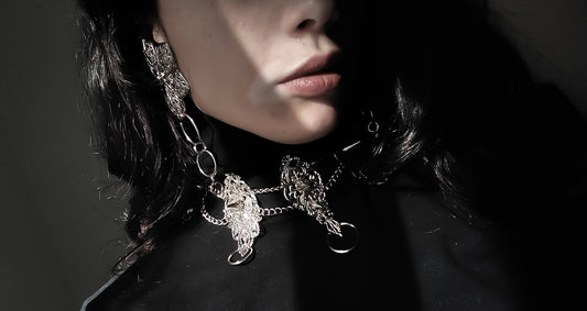 A close-up image captures the essence of Myril Jewels' craftsmanship with a punk studded metal choker adorned by an alternative model. The intricate design and studded detailing reflect a Neo Gothic influence, making it a coveted piece for those who appreciate Halloween jewelry, punk style, and Gothic-chic trends. The choker's bold presence is perfect for Whimsigoth and Witchcore enthusiasts or as a distinct touch to minimal goth daily wear