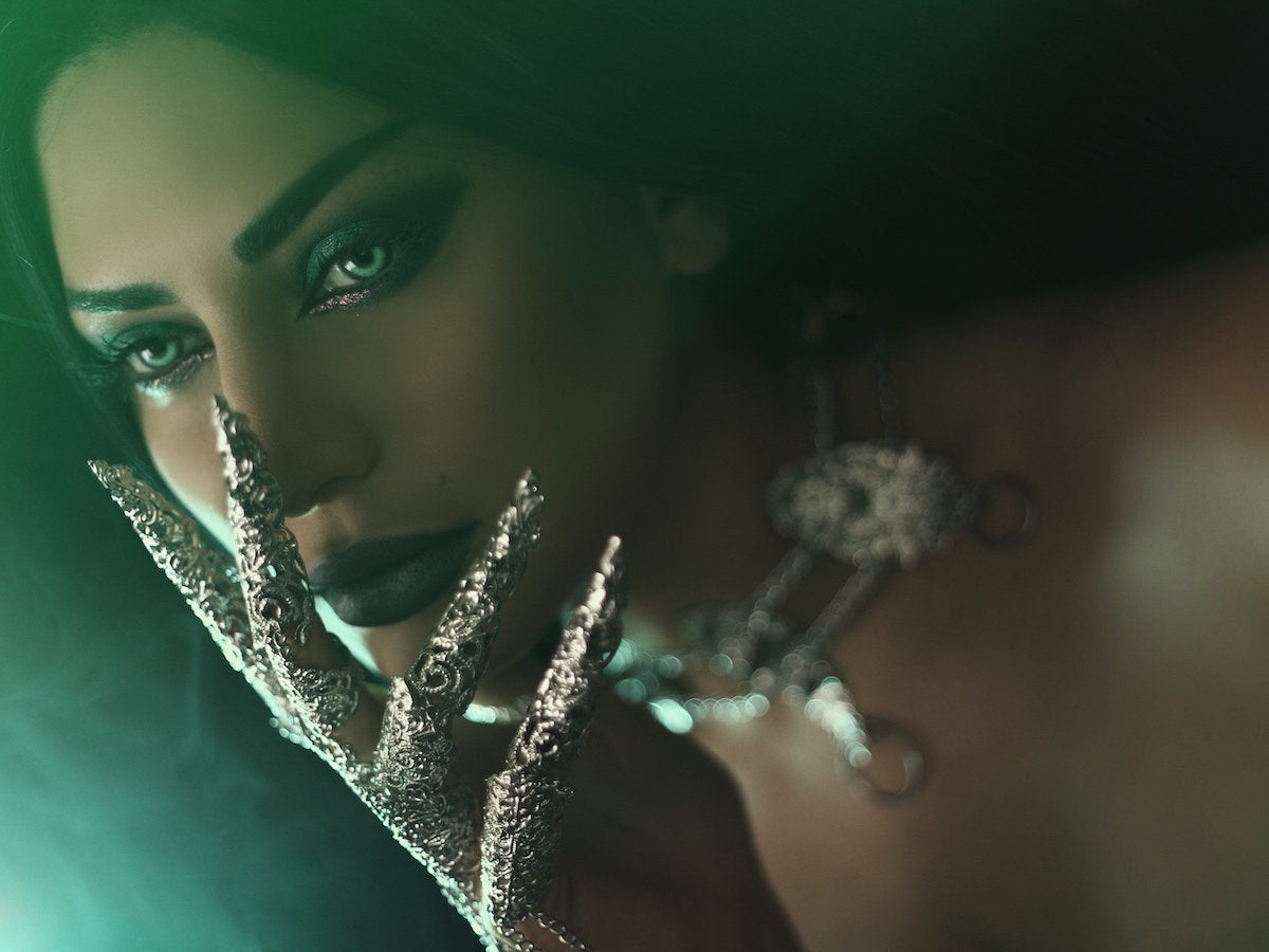Mystique emanates from a close-up of a woman adorned with Myril Jewels' neo gothic full finger claw ring. The dark, avant-garde jewelry complements her gothic-chic makeup, making a bold statement synonymous with Halloween Jewelry and Witchcore trends.
