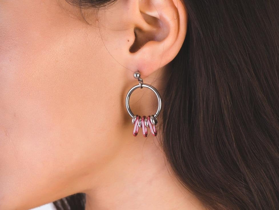 A model presents Myril Jewels' petite hoop earrings, combining polished silver with elegant pink details for a neo-gothic charm. These earrings are a perfect accessory for those who love to blend dark-avantgarde elements into their everyday gothic-chic style, making them a versatile addition for Halloween, everyday fashion, or as a thoughtful gift.