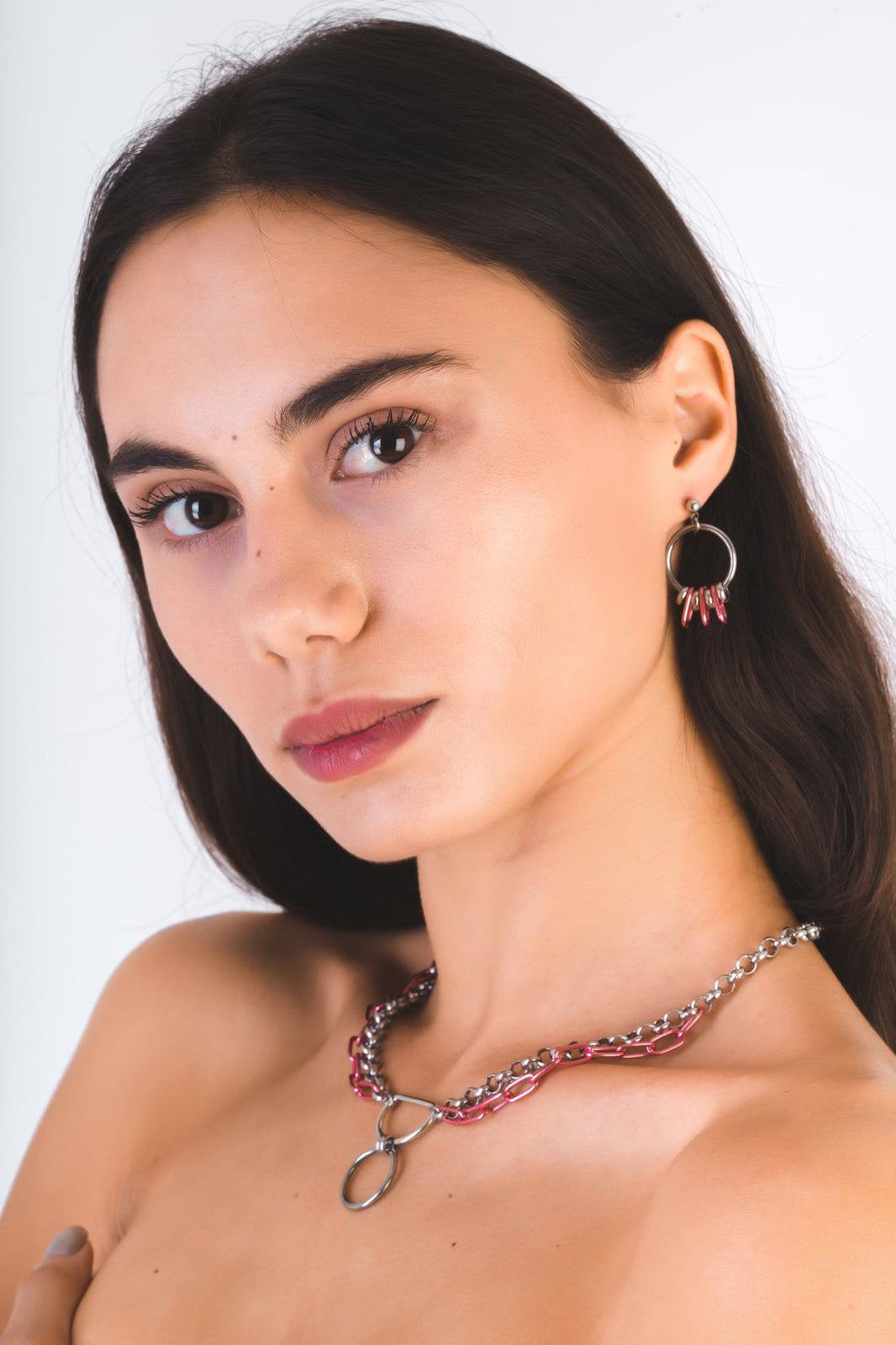 A model showcases Myril Jewels' neo-goth flair with silver hoop earrings featuring elegant pink details, complemented by a matching avant-garde chain necklace. This set is perfect for gothic fashion enthusiasts and adds a bold touch to any dark-avantgarde, Witchcore, or festival ensemble