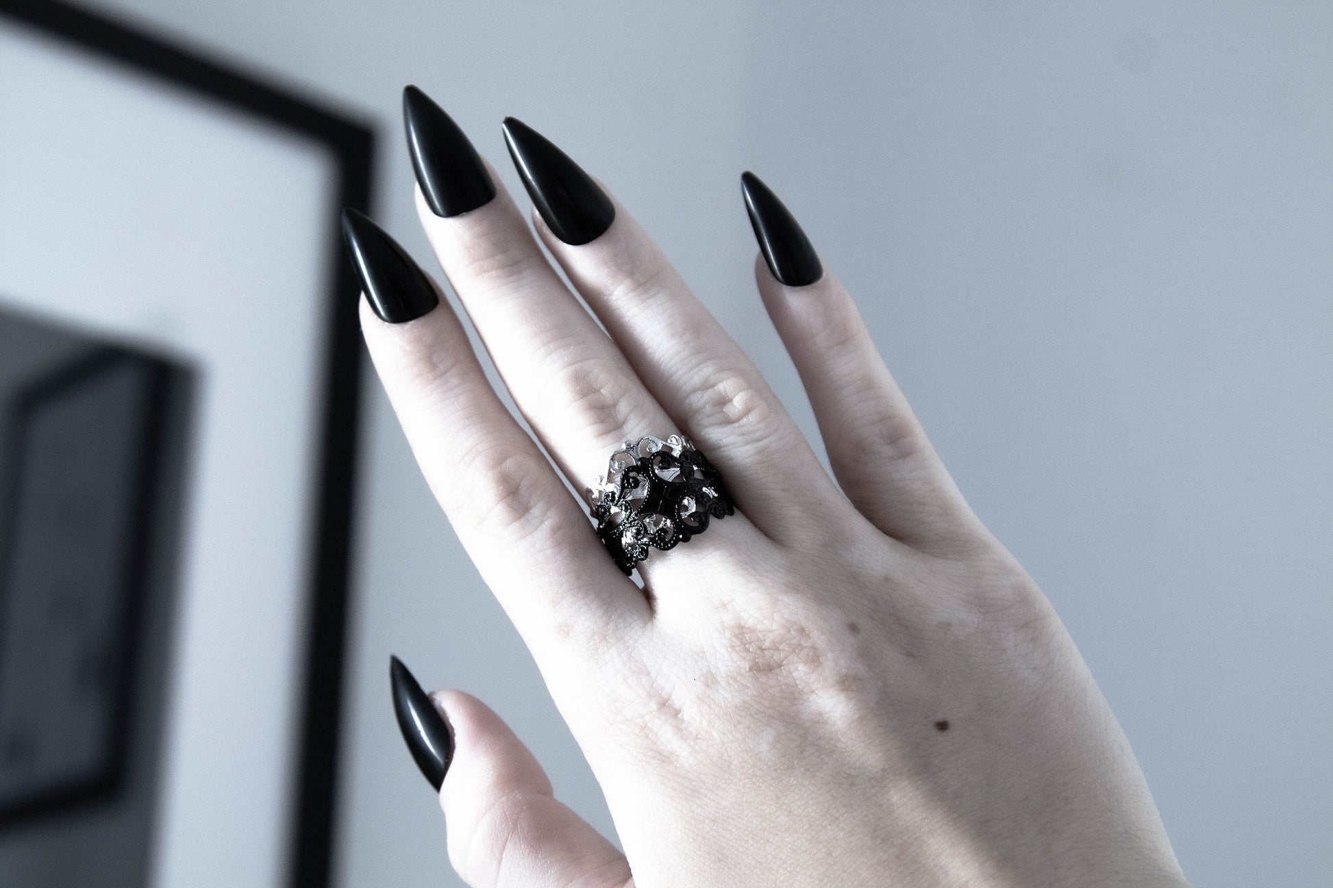 Myril Jewels' signature dark-avantgarde ring graces a hand with bold black nails, embodying the essence of Neo Gothic style. This statement piece, perfect for Gothic Lolita, Gothic-chic, and Witchcore enthusiasts, adds a touch of sophisticated punk to everyday wear. Ideal for Halloween or as a daring jewelry choice for those who celebrate the unique and alternative.