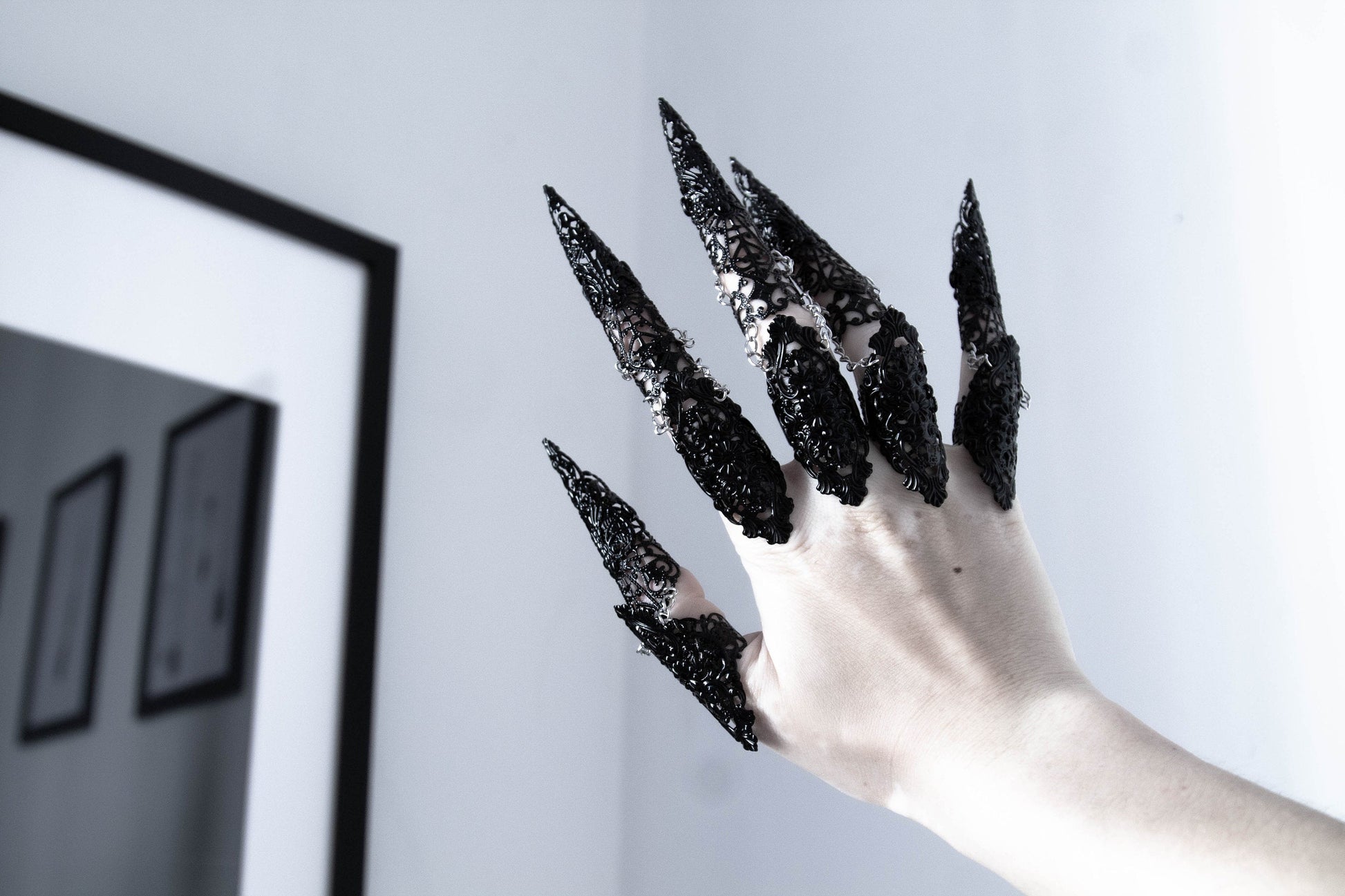 Striking Myril Jewels hand adornment, featuring gothic black full finger rings with elongated claws, merging witchcore aesthetics with neo-gothic design, perfect for an avant-garde fashion statement.