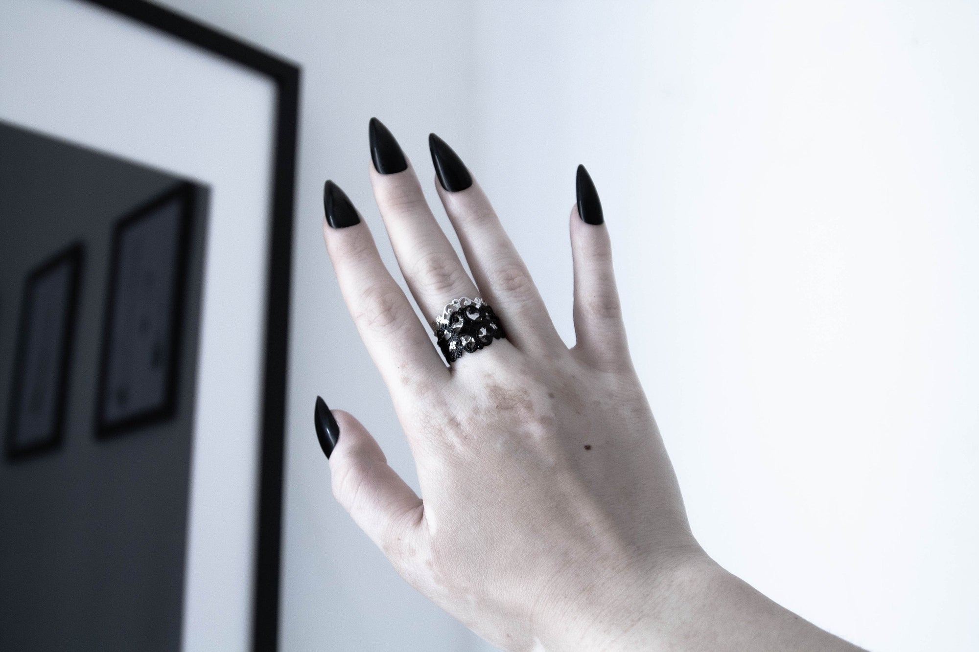 Myril Jewels' signature dark-avantgarde ring graces a hand with bold black nails, embodying the essence of Neo Gothic style. This statement piece, perfect for Gothic Lolita, Gothic-chic, and Witchcore enthusiasts, adds a touch of sophisticated punk to everyday wear. Ideal for Halloween or as a daring jewelry choice for those who celebrate the unique and alternative.