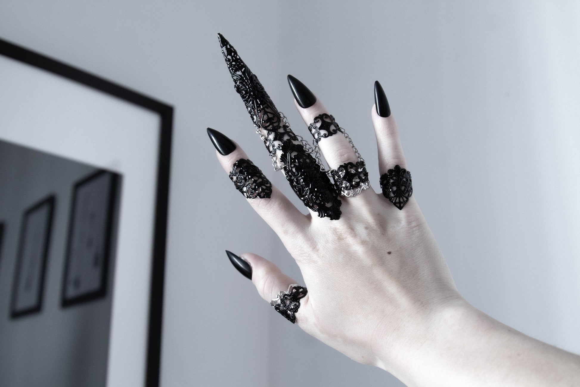 Hand adorned with Myril Jewels' neo-goth rings, showcasing intricate black filigree designs perfect for Halloween or everyday gothic-chic. A bold statement for festival wear or a unique goth girlfriend gift, embodying the dark-avantgarde spirit.