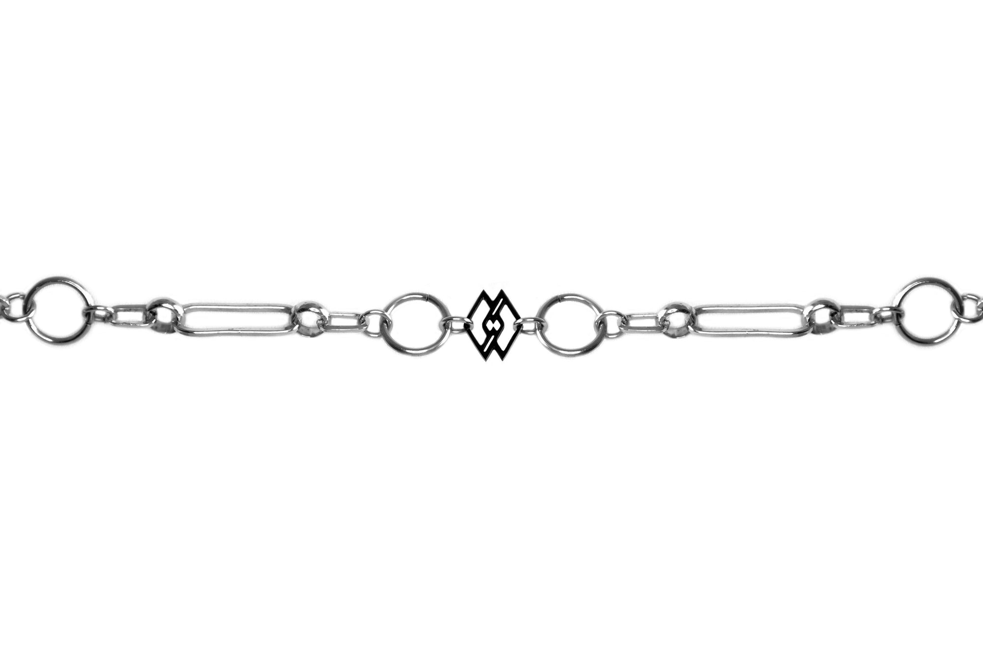 This is a sleek Myril Jewels chain-style bracelet, embodying a dark avant-garde aesthetic perfect for gothic and alternative fashion enthusiasts. The design showcases an intricate series of silver links, alternating between classic circular shapes and unique geometrical forms, culminating in a distinct rectangular charm that adds a modern twist. Ideal for everyday wear, this piece seamlessly fits into a minimal goth wardrobe while making a subtle statement. 